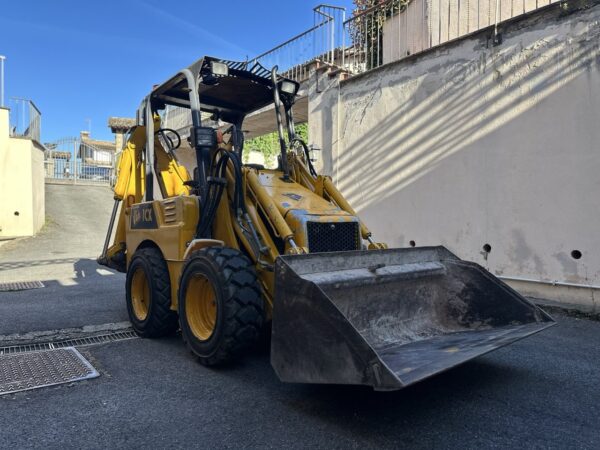 a yellow tractor with a bucket on the side of a road