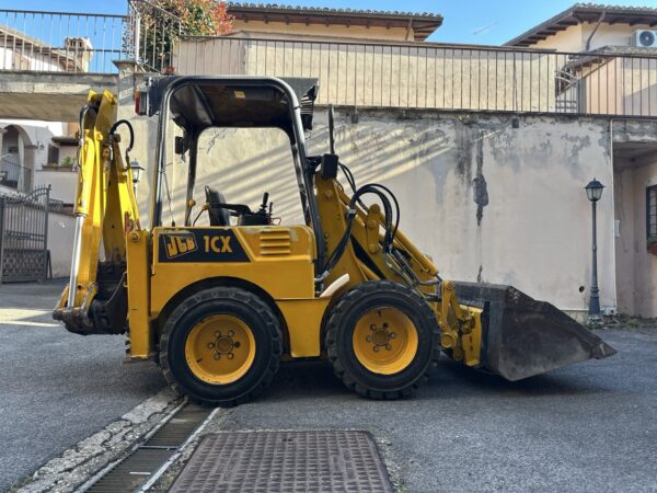 a yellow construction vehicle with a bucket on the side of the road