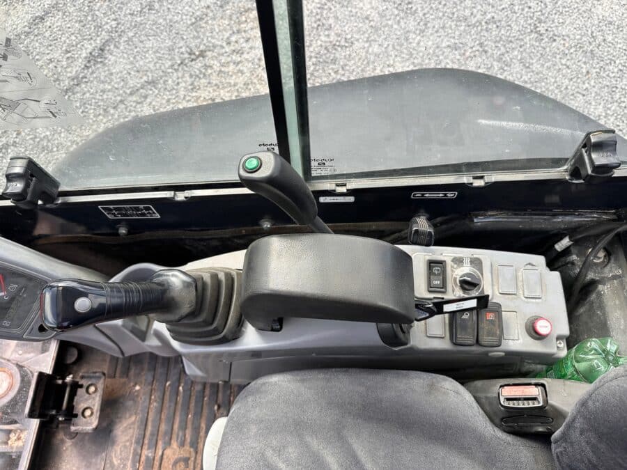 Vista interna comandi miniescavatore Kubota U27-4 con cabina chiusa