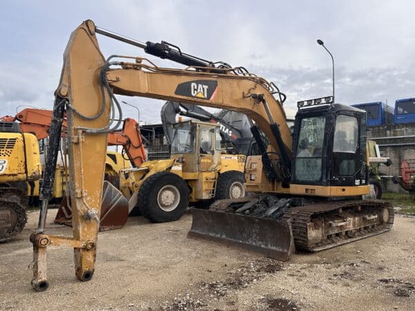 Escavatore Caterpillar 314D vista frontale sul piazzale DAMAC Roma