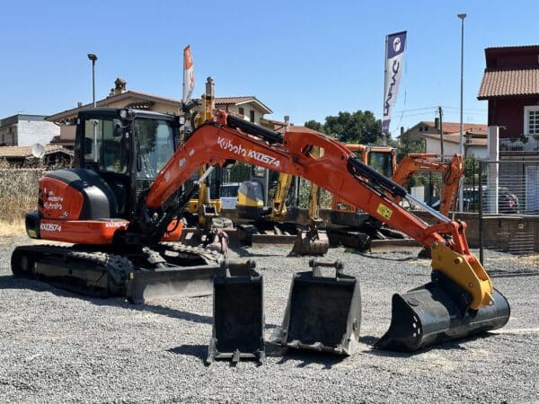 Kubota KX57-4 usato in piazzale con braccio esteso e benna da scavo montata.