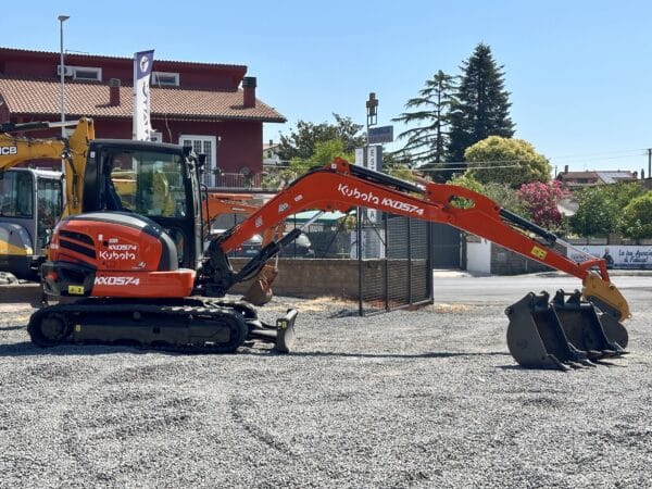 Miniescavatore Kubota KX57-4 vista laterale con braccio operativo e cabina chiusa.