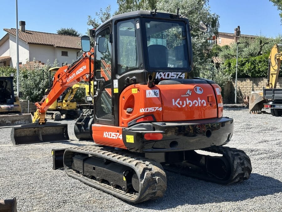 Kubota KX57-4 vue arrière latérale avec cabine fermée et train fixe.