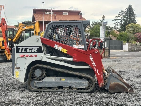 Minipala cingolata Takeuchi TL6R in vendita da DAMAC con braccio sollevato.