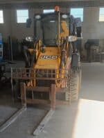 Mixta compacta JCB 1CX-HF vista frontal con cabina abierta y equipamiento para movimiento de materiales