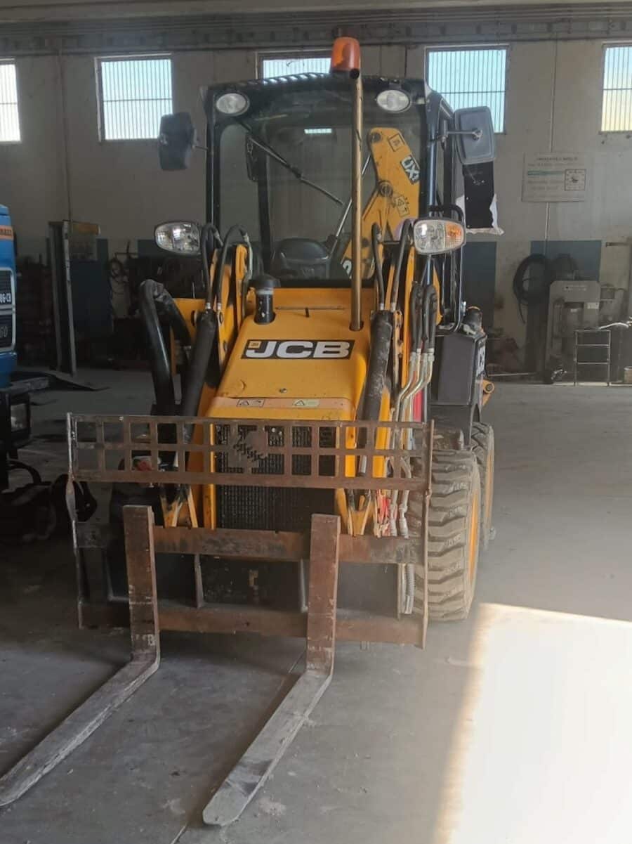 Mixta compacta JCB 1CX-HF vista frontal con cabina abierta y equipamiento para movimiento de materiales
