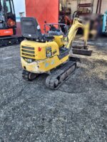 Komatsu PC09 usada, vista trasera izquierda con contrapeso compacto y orugas de goma