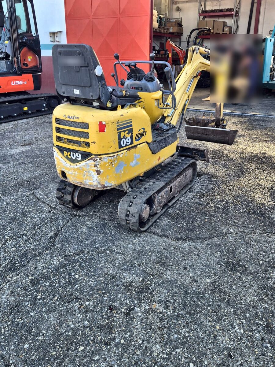 Komatsu PC09 usada, vista trasera izquierda con contrapeso compacto y orugas de goma