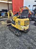 Vista trasera derecha de la Komatsu PC09 usada con asiento, mandos y arco de seguridad