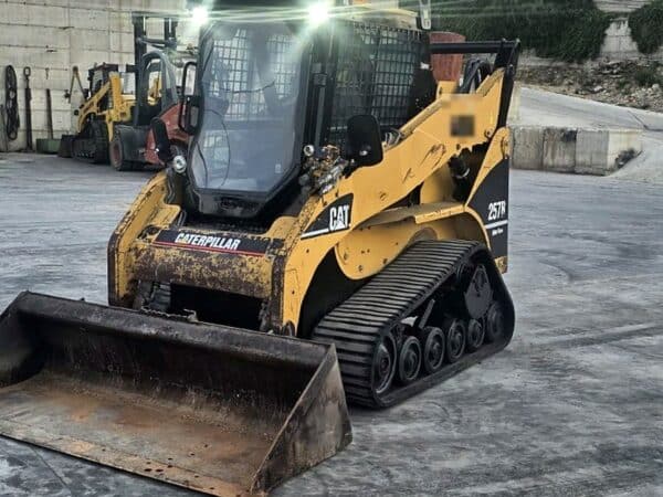 Minipala cingolata Caterpillar 257B usata del 2008, vista anteriore sinistra con benna, in provincia di Foggia