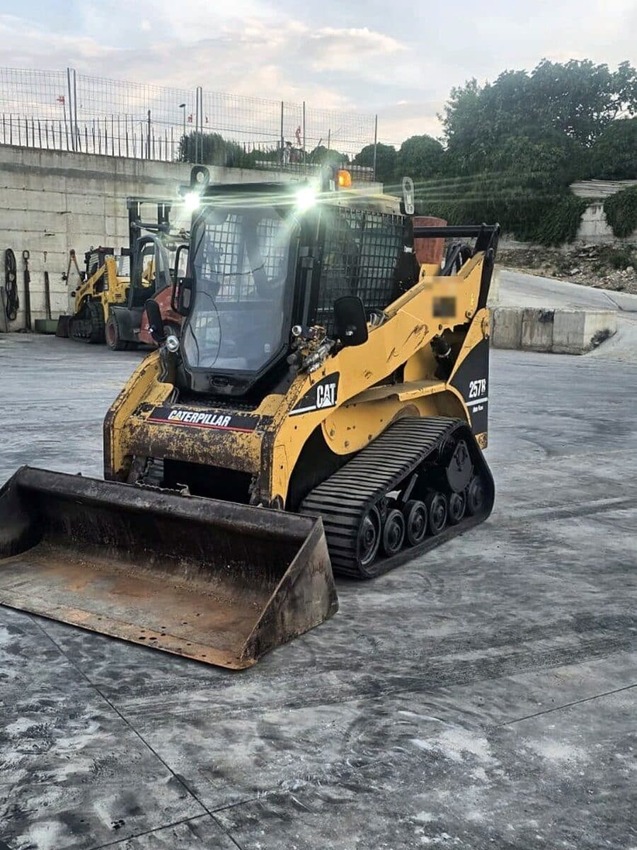 Minipala cingolata Caterpillar 257B usata del 2008, vista anteriore sinistra con benna, in provincia di Foggia